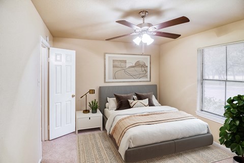 a bedroom with a large bed and a ceiling fan at Village Oaks Apartments, Texas, 78759